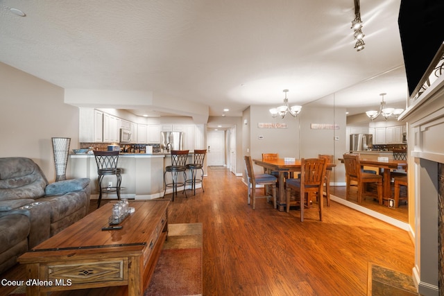 4549 S Arrow Point Dr # 207, Harrison, ID 83833 - living area featuring baseboards, wood finished floors, and a chandelier