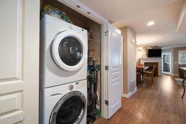 4549 S Arrow Point Dr # 207, Harrison, ID 83833 - laundry area with baseboards, wood finished floors, stacked washing maching and dryer, and laundry area