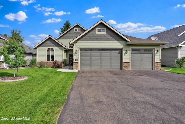 craftsman-style house with a garage, driveway, stone siding, and a front lawn