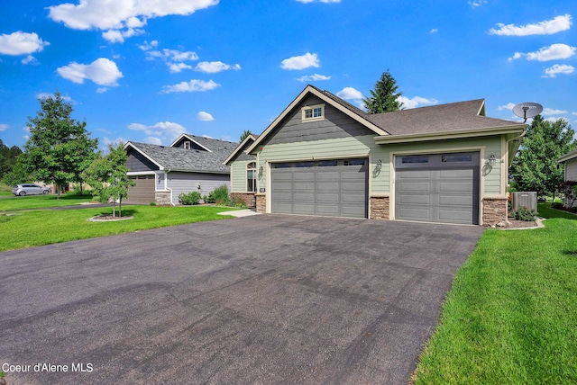 craftsman-style house with driveway, a front yard, central air condition unit, and a garage