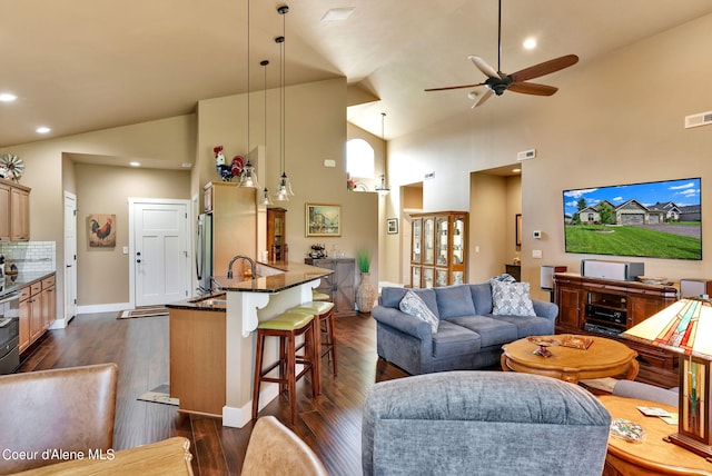 living area featuring ceiling fan, visible vents, baseboards, high vaulted ceiling, and dark wood-style flooring
