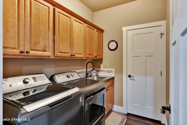 clothes washing area featuring cabinet space, washing machine and clothes dryer, dark wood-style flooring, and a sink