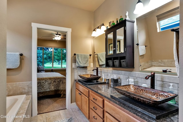 ensuite bathroom with a bath, tasteful backsplash, ensuite bathroom, and a sink
