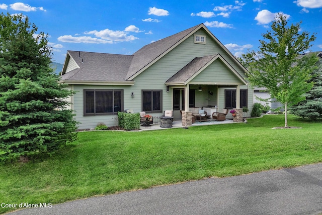 back of house featuring a ceiling fan, an outdoor hangout area, a yard, a patio area, and roof with shingles
