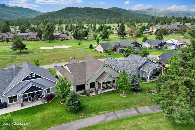 drone / aerial view featuring a mountain view, a view of trees, and a residential view