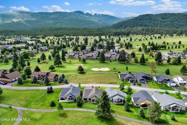 drone / aerial view featuring a residential view, a wooded view, and a mountain view