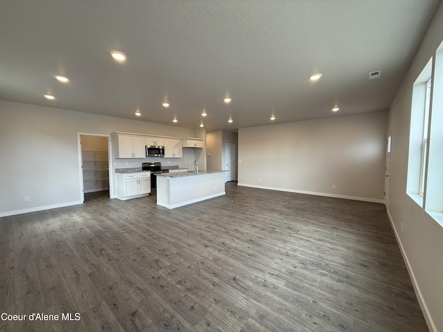 5147 E Norma Ave, Post Falls, ID 83854 - unfurnished living room featuring dark wood-type flooring and recessed lighting