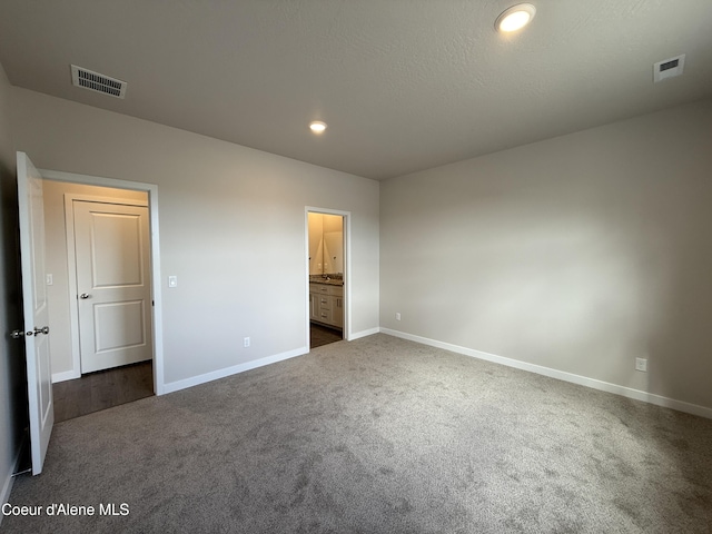 5147 E Norma Ave, Post Falls, ID 83854 - unfurnished bedroom with dark carpet, recessed lighting, and ensuite bathroom