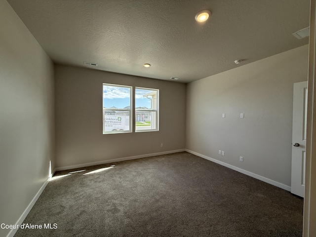 5147 E Norma Ave, Post Falls, ID 83854 - spare room featuring dark colored carpet, a textured ceiling, and a smoke detector