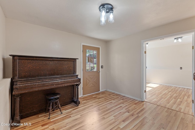 foyer entrance featuring light wood-style floors and baseboards