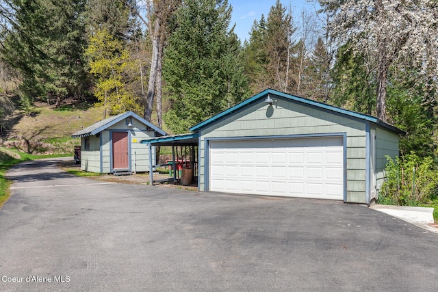 view of front of home featuring a shed, an outdoor structure, and a detached garage