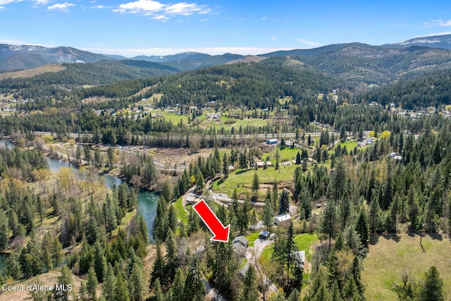 aerial view with a water and mountain view and a forest view