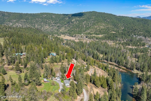 aerial view featuring a wooded view and a water and mountain view