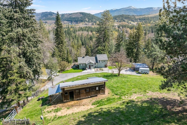 birds eye view of property featuring a mountain view and a wooded view
