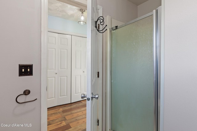 bathroom featuring a shower stall and wood finished floors