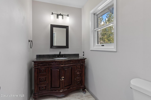 bathroom with baseboards, marble finish floor, vanity, and toilet