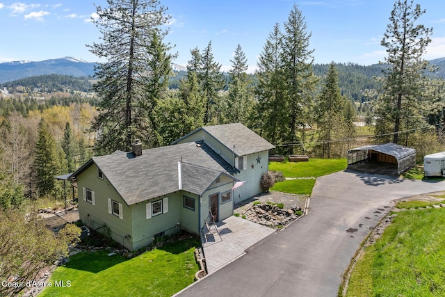 birds eye view of property featuring a mountain view and a wooded view