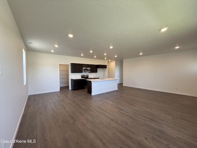 5119 E Rigel Ln, Post Falls, ID 83854 - unfurnished living room with dark wood-style floors, recessed lighting, and a textured ceiling