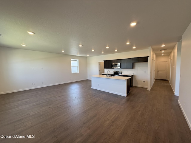 5119 E Rigel Ln, Post Falls, ID 83854 - kitchen featuring stainless steel appliances, open floor plan, dark wood finished floors, a kitchen island with sink, and recessed lighting