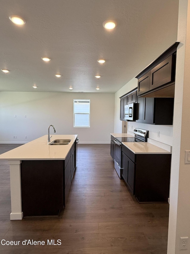 5119 E Rigel Ln, Post Falls, ID 83854 - kitchen featuring appliances with stainless steel finishes, dark wood-style flooring, an island with sink, light countertops, and recessed lighting