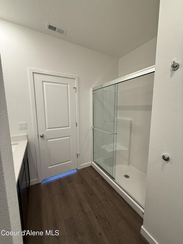 5119 E Rigel Ln, Post Falls, ID 83854 - bathroom with wood finished floors, a shower stall, and vanity