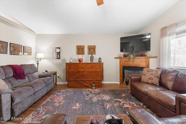8514 W Grand Teton St, Rathdrum, ID 83858 - living room with a glass covered fireplace, vaulted ceiling, baseboards, and wood finished floors