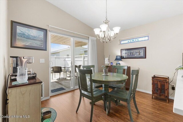 8514 W Grand Teton St, Rathdrum, ID 83858 - dining room featuring lofted ceiling, baseboards, wood finished floors, and an inviting chandelier