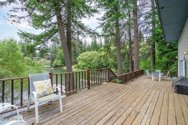 14314 N Waters Edge Ct, Hayden, ID 83835 - wooden terrace with outdoor dining space and view of wooded area