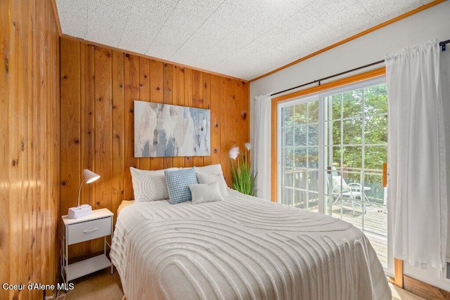 14314 N Waters Edge Ct, Hayden, ID 83835 - bedroom with ornamental molding, access to outside, and wood walls