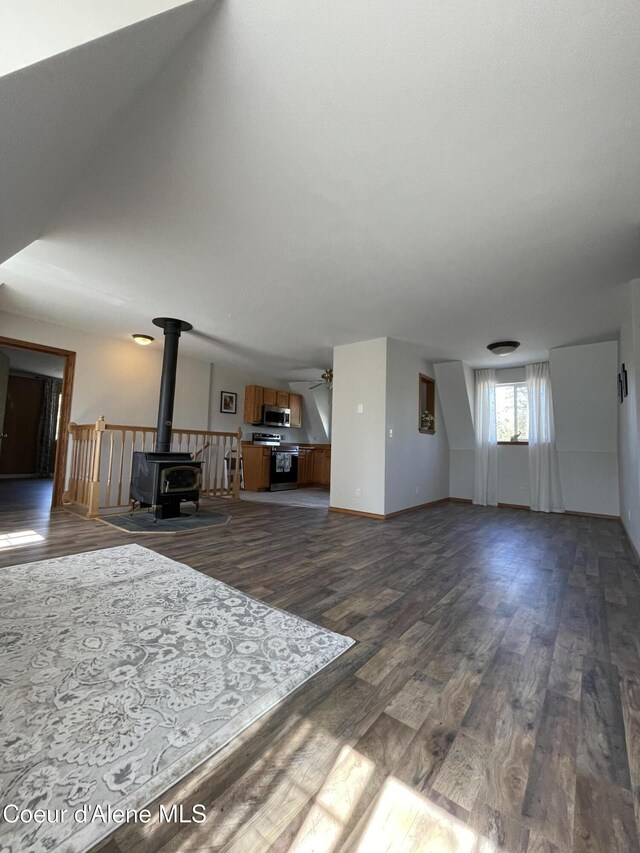 24731 N Wendler Loop, Rathdrum, ID 83858 - living area with baseboards, a wood stove, and dark wood-style floors