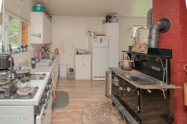 2884 Morris Rd, Naples, ID 83847 - kitchen with a sink, light wood-style floors, white appliances, light countertops, and white cabinetry