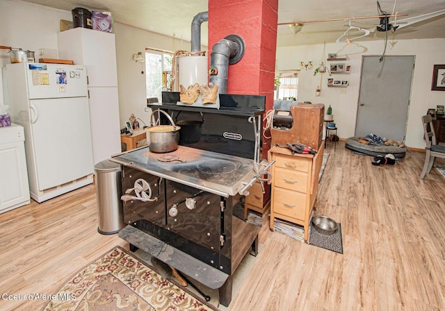 2884 Morris Rd, Naples, ID 83847 - kitchen featuring wood finished floors, freestanding refrigerator, and a wood stove