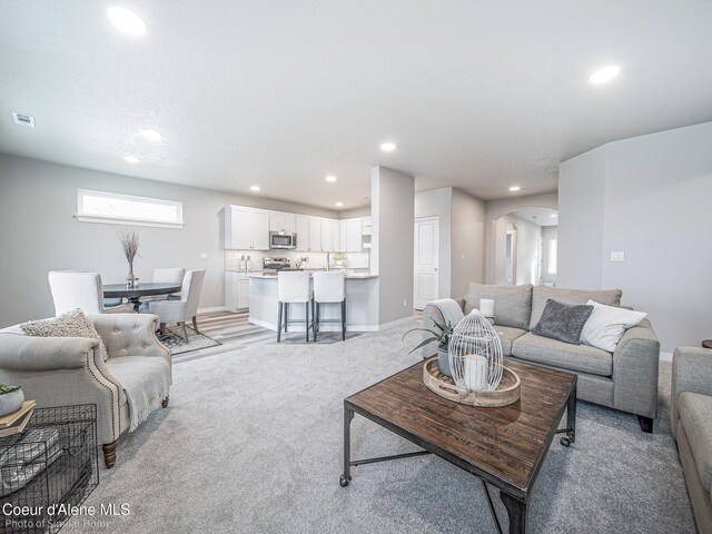 13748 N Apex Way, Hayden, ID 83835 - living room featuring visible vents, recessed lighting, arched walkways, and light colored carpet