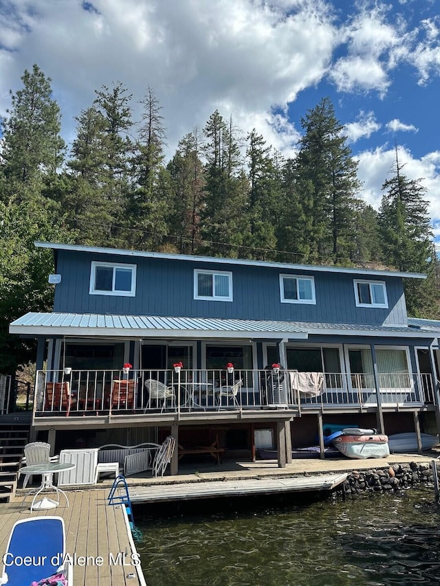 back of property with metal roof and a water view