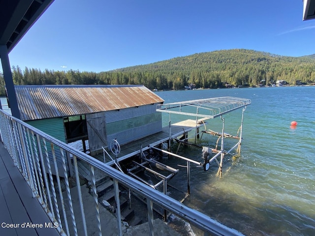 dock with a view of trees, boat lift, and a water view