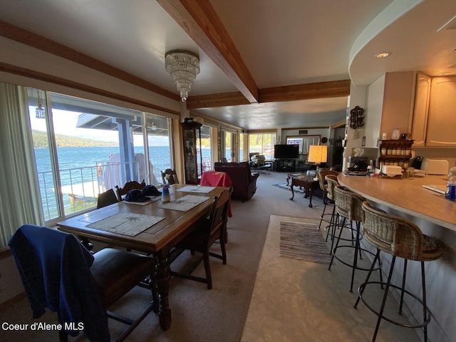 dining space with light carpet and beam ceiling