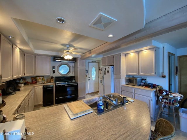 kitchen featuring black electric range oven, white fridge with ice dispenser, light countertops, stainless steel microwave, and a peninsula