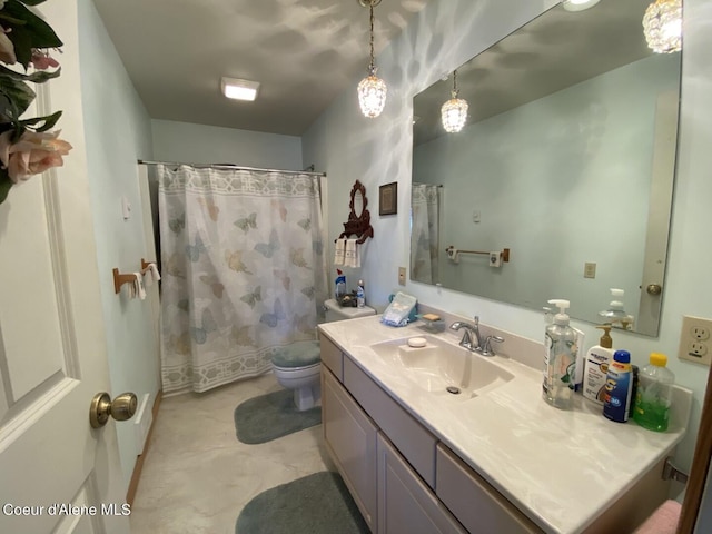 bathroom featuring toilet, vanity, and curtained shower