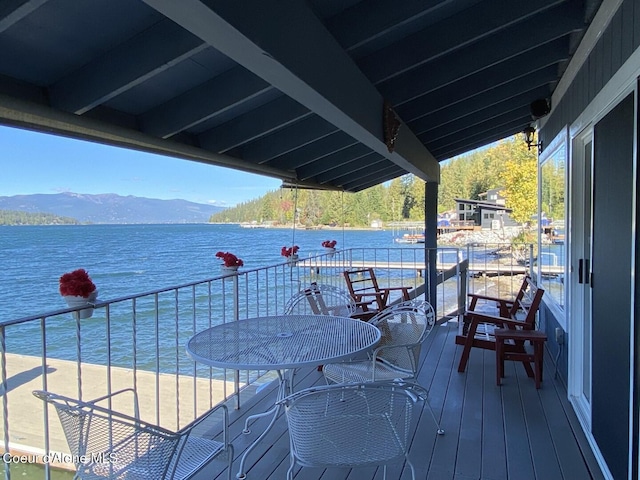 wooden terrace with a water and mountain view