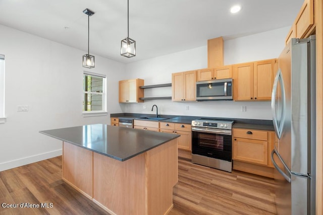 50 Carnelian Ave Unit 203, Ponderay, ID 83852 - kitchen featuring dark countertops, appliances with stainless steel finishes, light brown cabinetry, and a sink