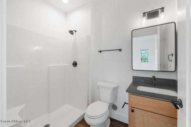50 Carnelian Ave Unit 203, Ponderay, ID 83852 - bathroom with a walk in shower, baseboards, vanity, and toilet