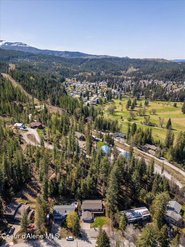 birds eye view of property with a wooded view and a mountain view