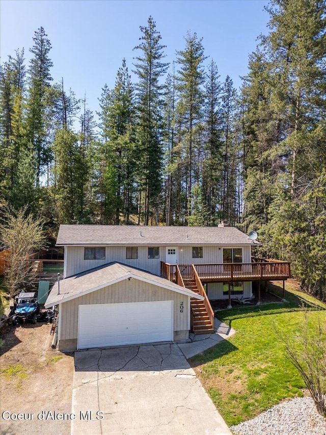 view of front of house featuring stairway, a garage, a wooden deck, driveway, and a front lawn