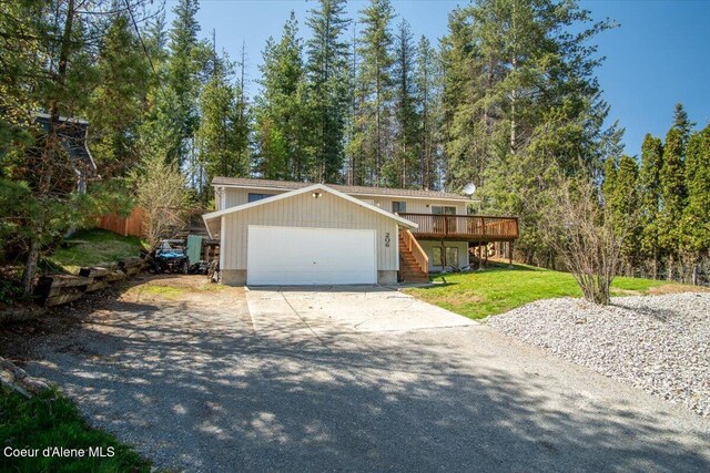 view of front of house featuring a deck, stairway, a garage, a front lawn, and concrete driveway