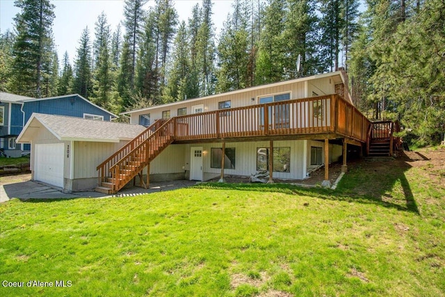 rear view of house featuring a wooden deck, a garage, a lawn, stairs, and driveway