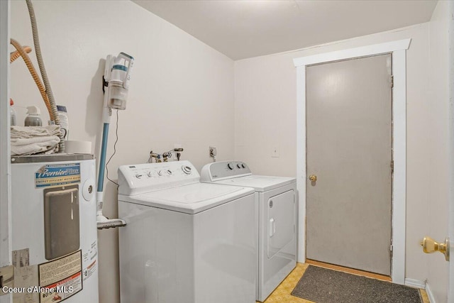 clothes washing area with washer and dryer, laundry area, and electric water heater