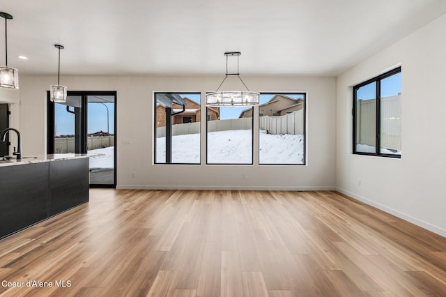 NNN Rocky Rd, Rathdrum, ID 83858 - unfurnished dining area featuring light wood-style floors, baseboards, a sink, and a notable chandelier