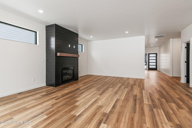 NNN Rocky Rd, Rathdrum, ID 83858 - unfurnished living room with wood finished floors, a fireplace, baseboards, visible vents, and recessed lighting