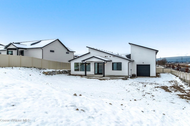 NNN Rocky Rd, Rathdrum, ID 83858 - snow covered back of property featuring an attached garage and fence