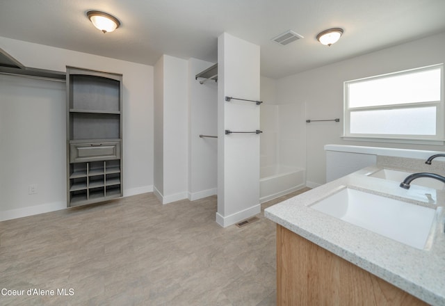 full bathroom with washtub / shower combination, visible vents, vanity, and baseboards